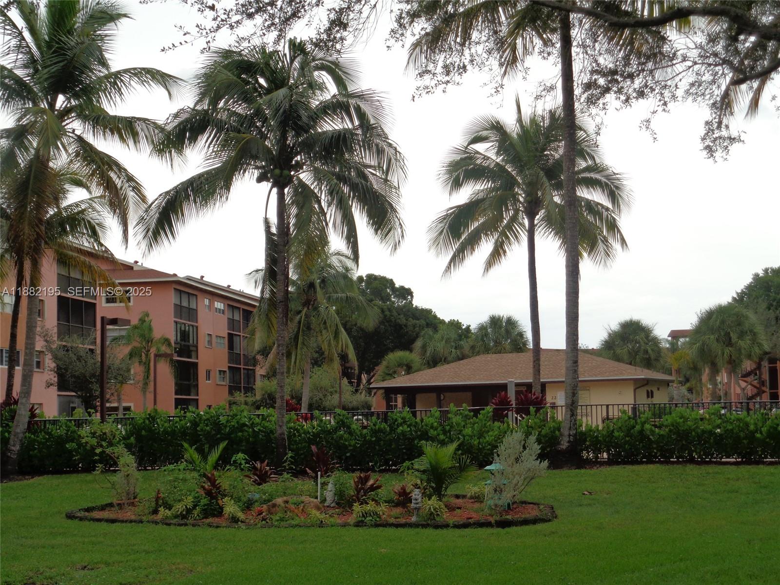 701 Southwest 141st Avenue, Unit 412R Pembroke Pines, FL 33027 - Photo 7 of 52 a front view of multi story residential apartment building with yard and green space