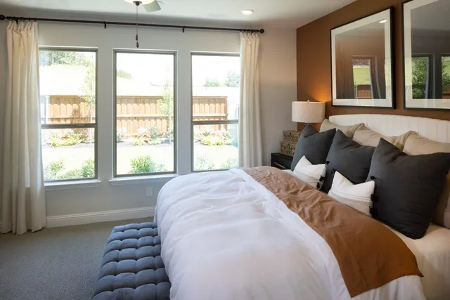 a bed sitting in a bedroom next to a window