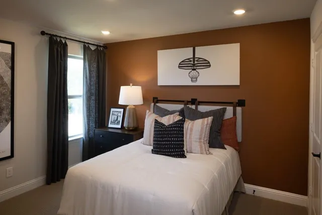 a bedroom with a bed and a painting on the wall