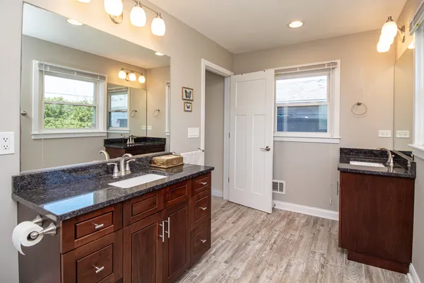 a bathroom with a granite countertop sink and a mirror