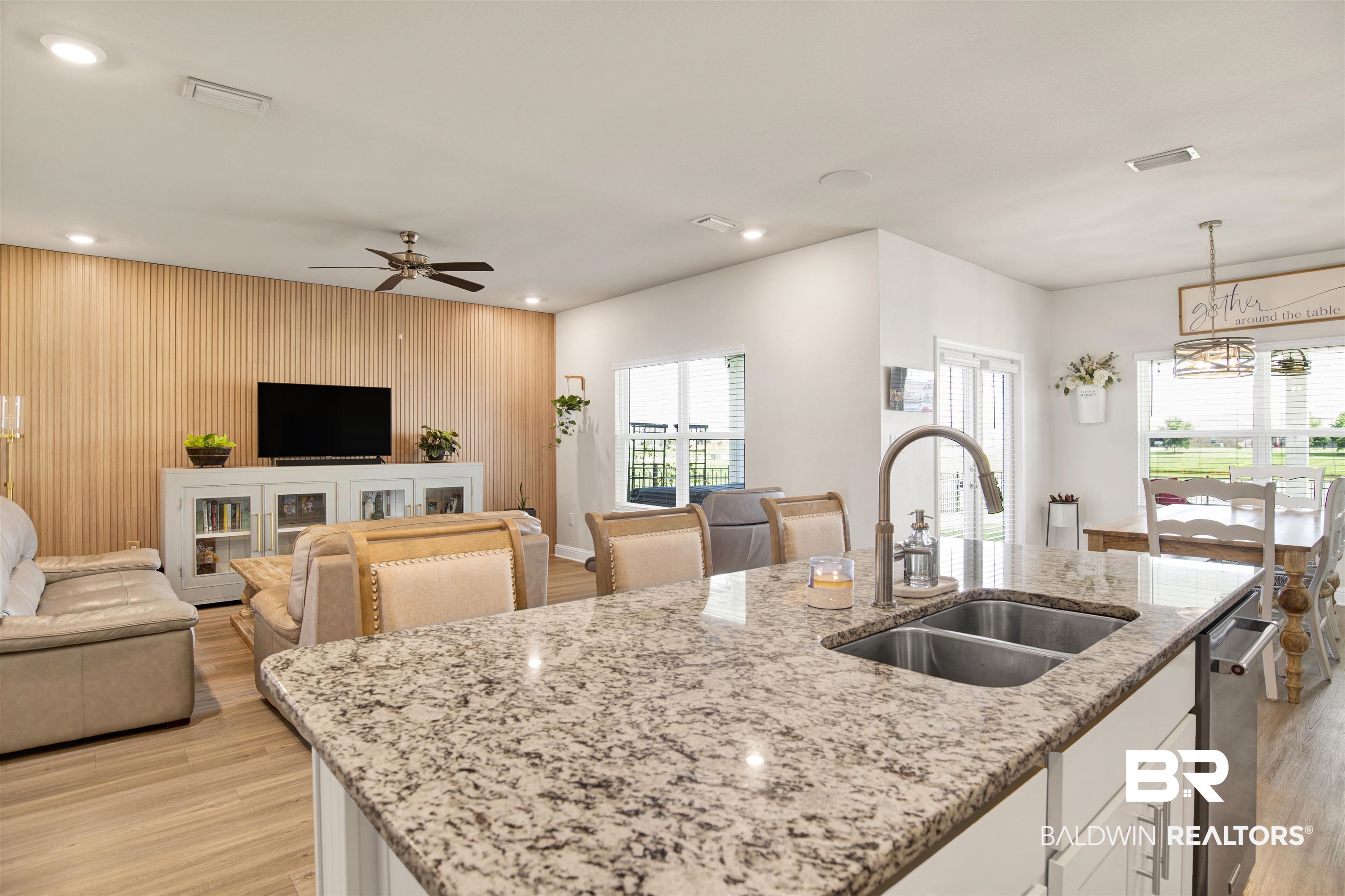 9431 Swan Point Road Daphne, AL 36526 - Photo 35 of 35 Kitchen with open floor plan, light wood finished floors, white cabinetry, wood walls, and light stone counters