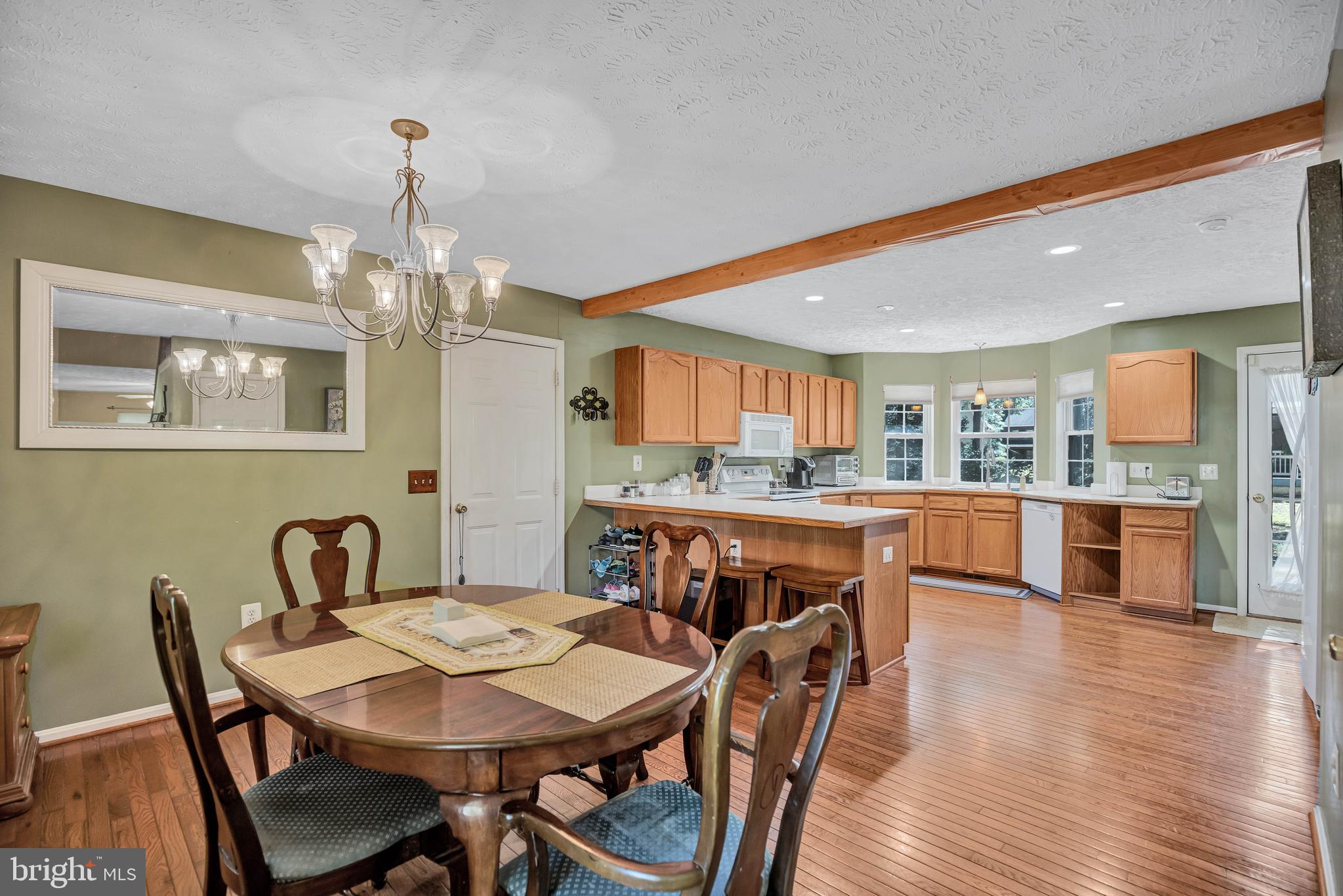 11535 Honeysuckle Court Issue, MD 20645 - Photo 7 of 21 a view of a dining room and livingroom with furniture wooden floor a chandelier