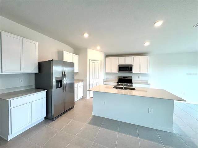 a kitchen with stainless steel appliances a refrigerator sink and stove