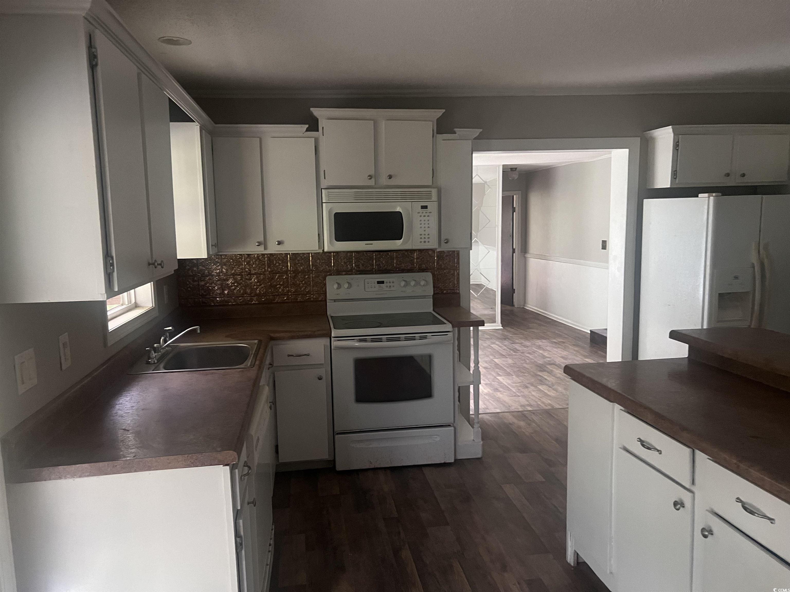 4675 Brailsford Circle Rembert, SC 29128 - Photo 3 of 20 Kitchen featuring white appliances, a sink, dark c