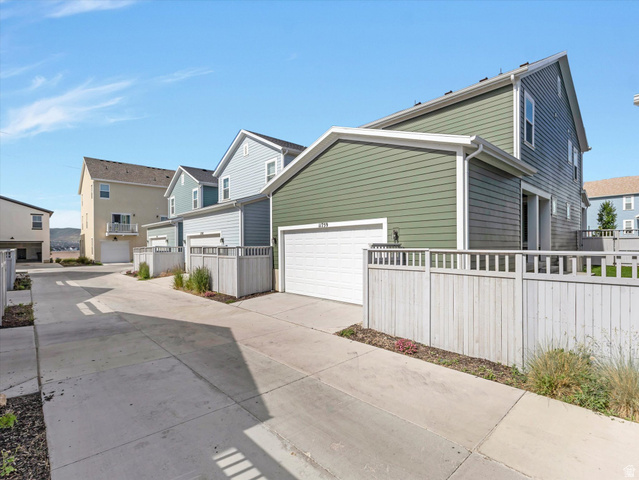 11759 South Watercourse Road South Jordan, UT 84009 - Photo 25 of 33 Townhome exteriors featuring horizontal siding in varied colors, individual garage access, and private fencing