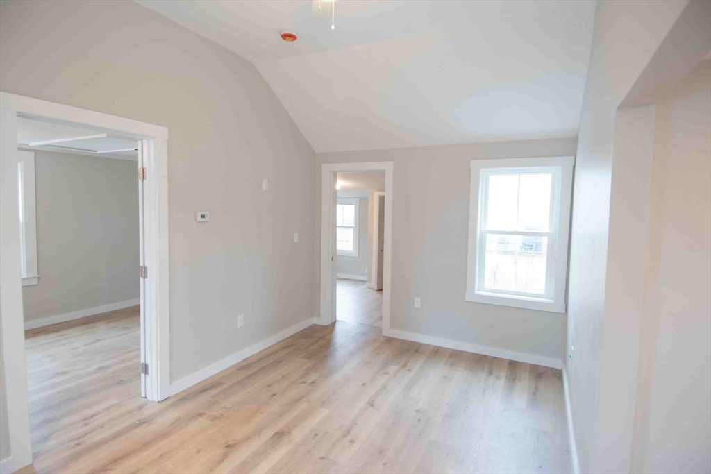 154 Denver Street Springfield, MA 01109 - Photo 8 of 10 an empty room with wooden floor and windows