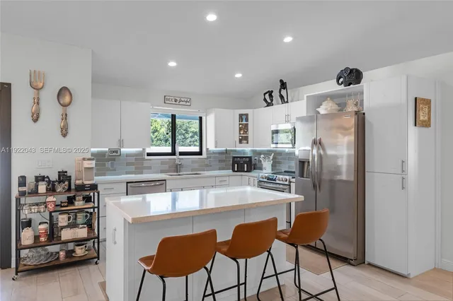 a kitchen with stainless steel appliances granite countertop a refrigerator and a stove top oven