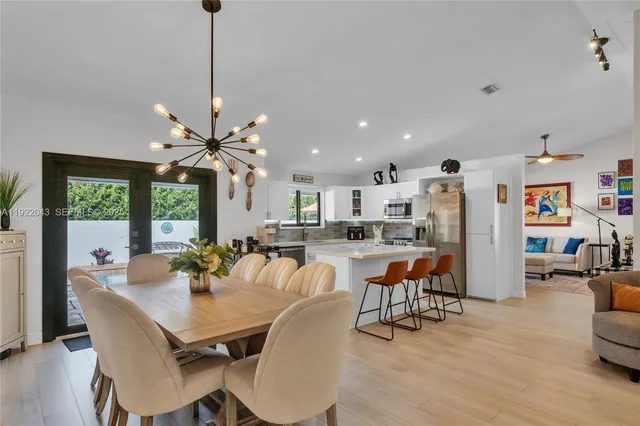 a dining room with furniture a chandelier and wooden floor