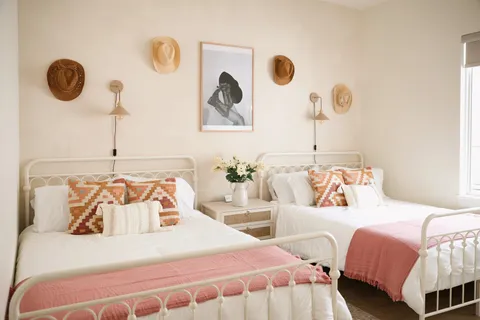 a bedroom with two beds and painting on the wall