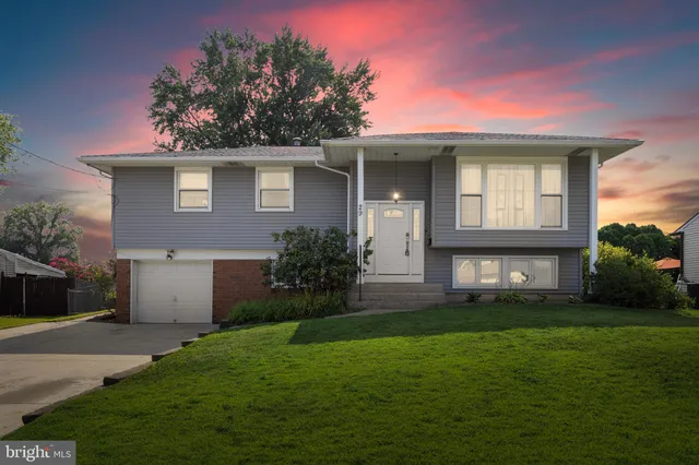 a front view of a house with a yard and potted plants