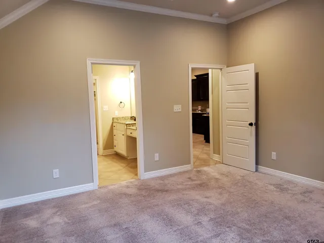 an empty room with an entryway and wooden door