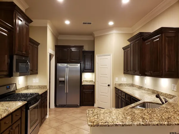 a kitchen with stainless steel appliances granite countertop a refrigerator and a sink
