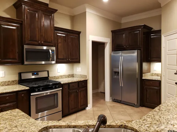 a kitchen with granite countertop stainless steel appliances and wooden cabinets