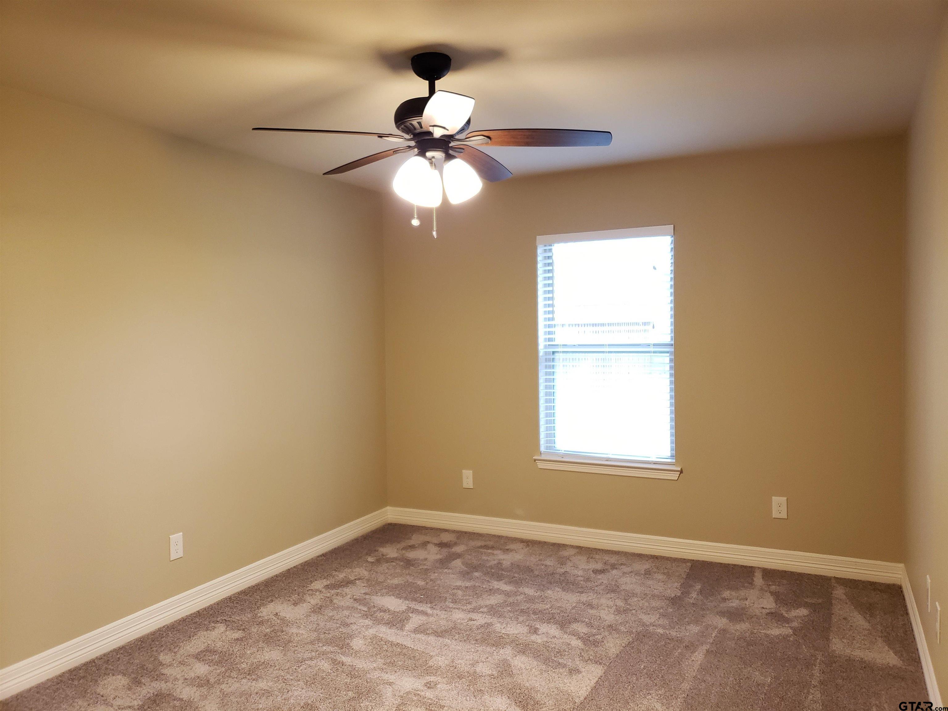 3700 Old Omen Road Tyler, TX 75707 - Photo 10 of 21 an empty room with windows and fan