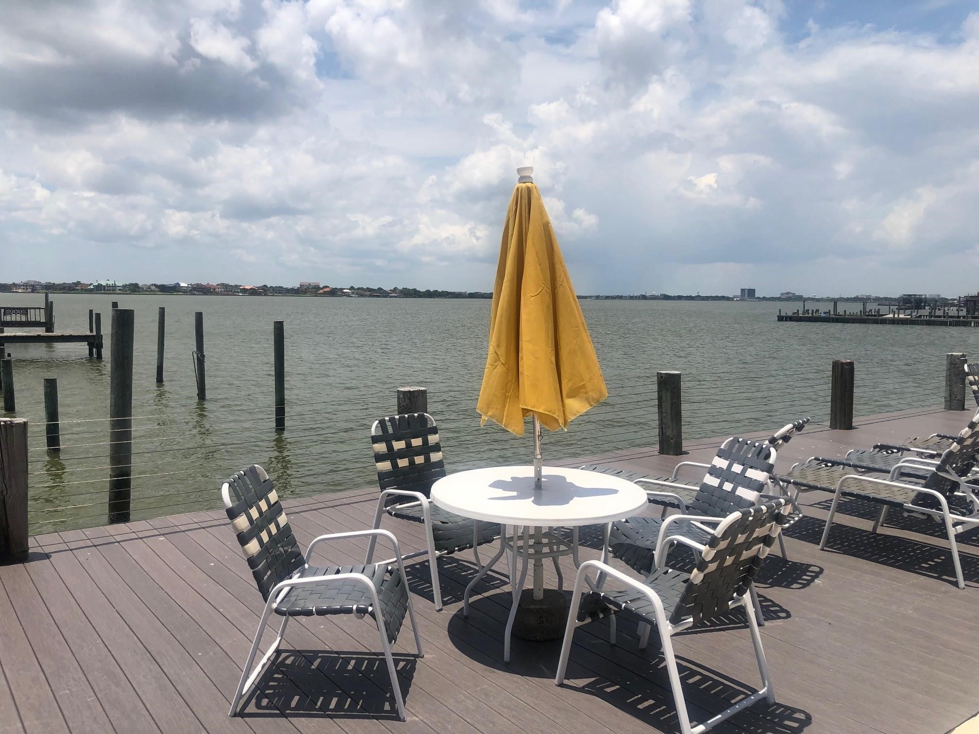 3535 NASA Road 1, Unit 49 Seabrook, TX 77586 - Photo 17 of 17 a view of a roof deck with table and chairs a barbeque with wooden floor and fence