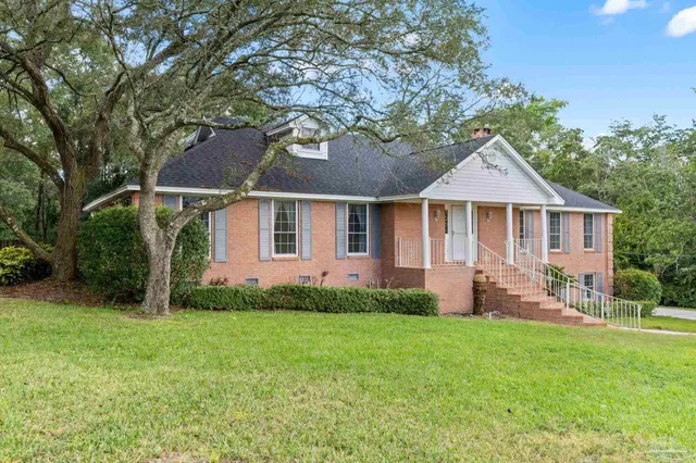 a front view of a house with a garden and yard