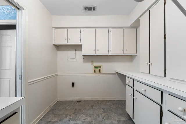 an empty room with windows and cabinet