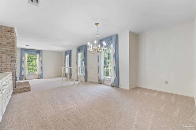 an empty room with a fireplace and windows