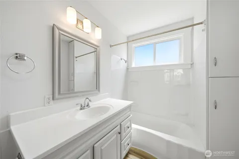 a bathroom with a granite countertop sink a mirror and a bathtub