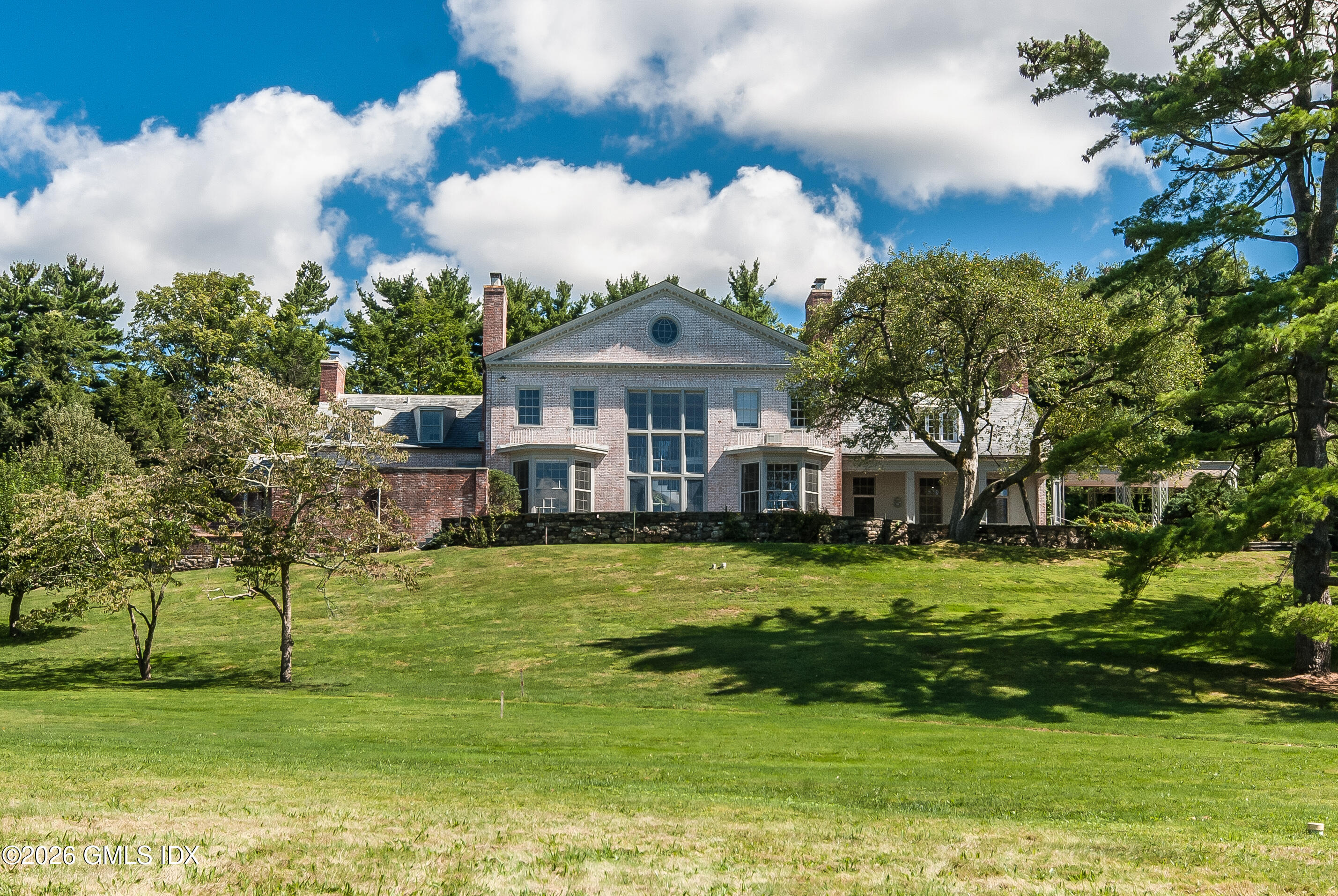 188 Round Hill Road Greenwich, CT 06831 - Photo 1 of 1 a front view of a house with a garden