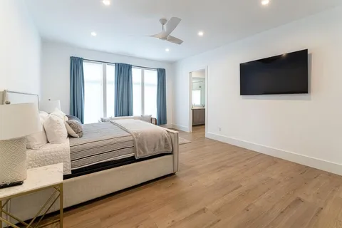 a bedroom with a large bed and a flat screen tv