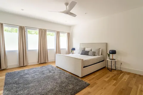 a white bed sitting in a room next to a window