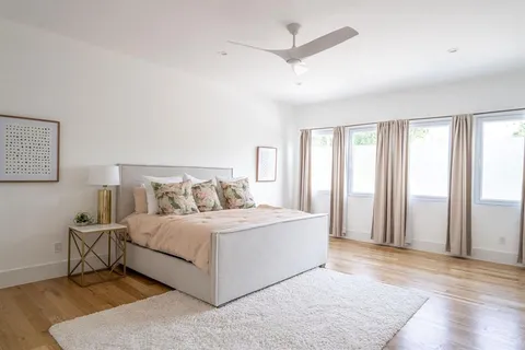 a living room with a bed furniture and a large window