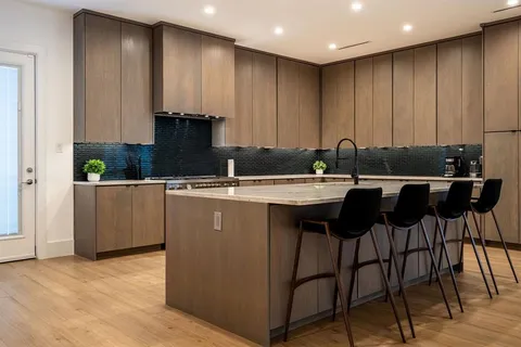 a kitchen with kitchen island granite countertop a sink counter top space and cabinets