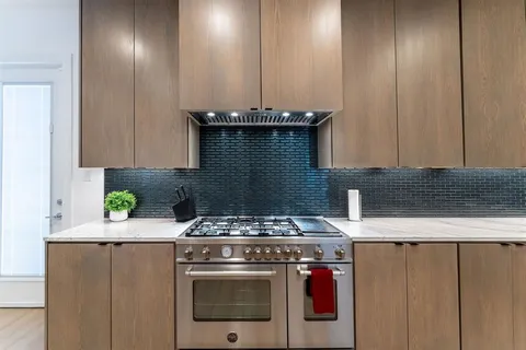 a stove top oven sitting inside of a kitchen