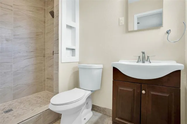 a bathroom with a sink a toilet and shower