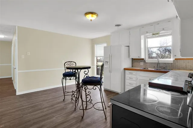 a kitchen with stainless steel appliances granite countertop a stove top oven a sink counter space and dining table