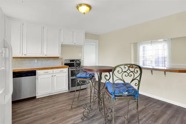 a kitchen with stainless steel appliances a stove a sink cabinets and wooden floor