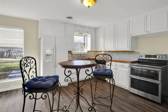 a kitchen with stainless steel appliances a dining table and chairs