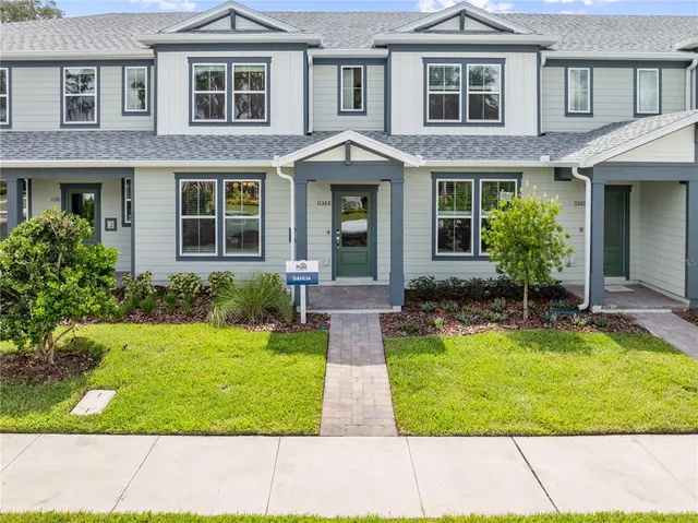 a front view of a house with yard and many windows