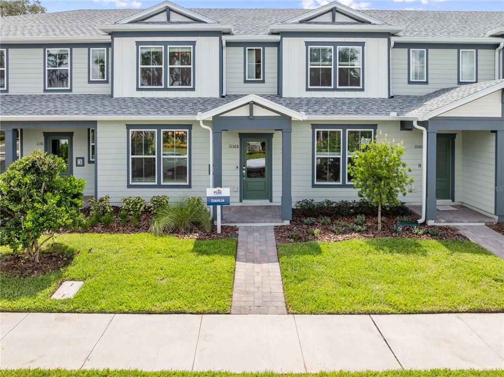 a front view of a house with yard and many windows