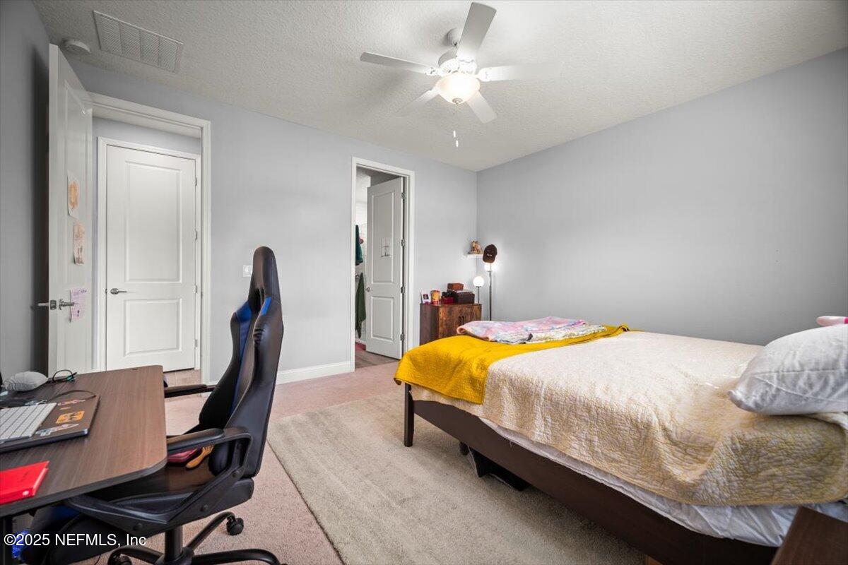 141 Killarney Avenue St. Johns, FL 32259 - Photo 14 of 33 a bedroom with a bed and a desk