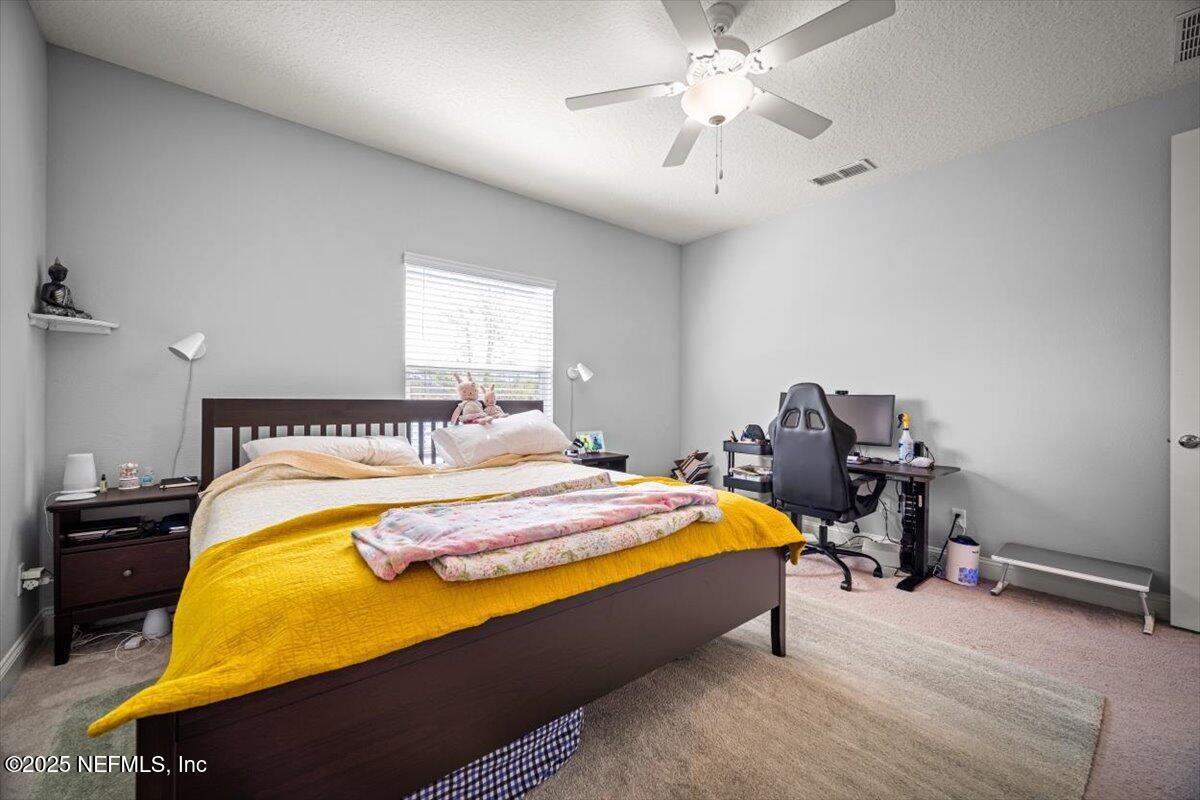 141 Killarney Avenue St. Johns, FL 32259 - Photo 16 of 33 a spacious bedroom with a bed and a chandelier