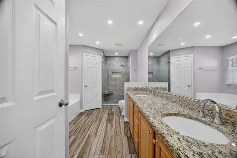 a spacious bathroom with a granite countertop sink a mirror and shower