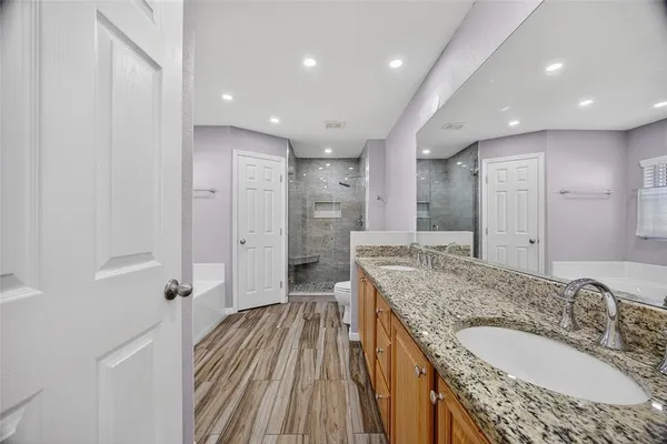 a spacious bathroom with a granite countertop sink a mirror and shower