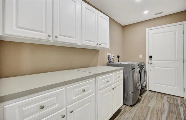 a utility room with cabinets washer and dryer