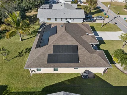 an aerial view of a house with swimming pool and big yard
