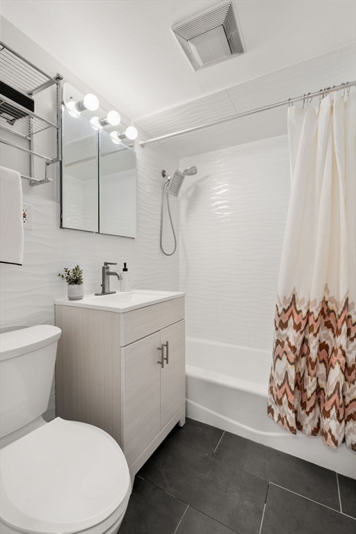 205 Kent Street, Unit 48 Brookline, MA 02446 - Photo 8 of 10 a bathroom with a sink mirror vanity and toilet