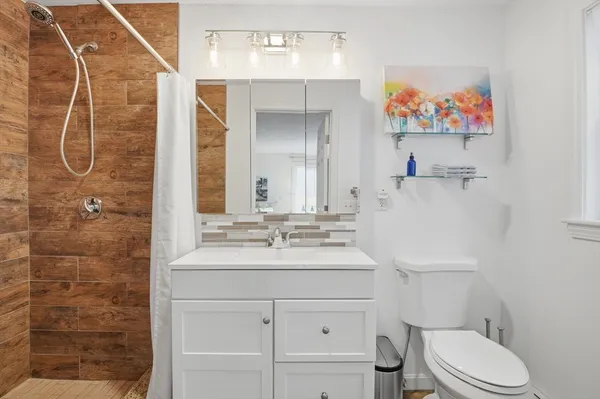a bathroom with a sink a toilet and shower