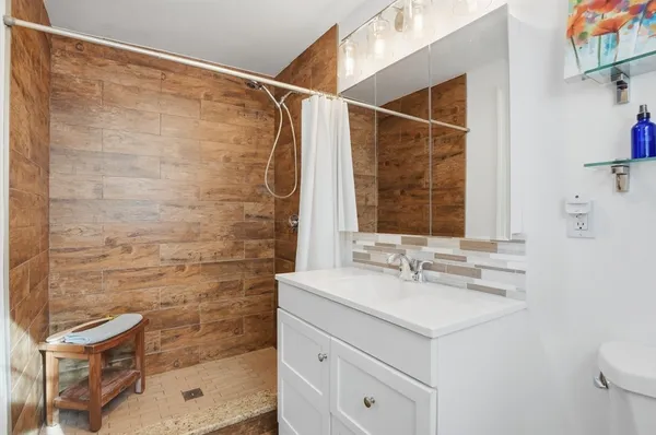 a bathroom with a sink mirror and a shower