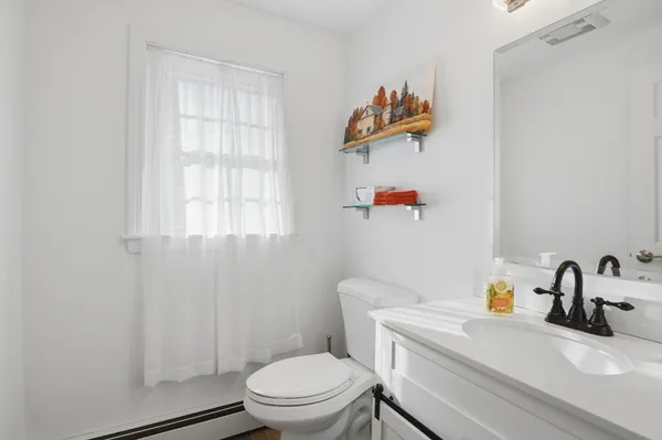 a bathroom with a sink mirror vanity and toilet