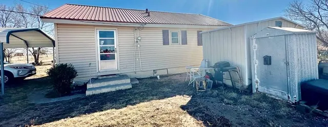 a view of a house with backyard and sitting area