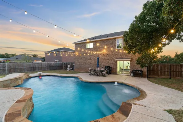 a view of a swimming pool with sitting area and fire pit
