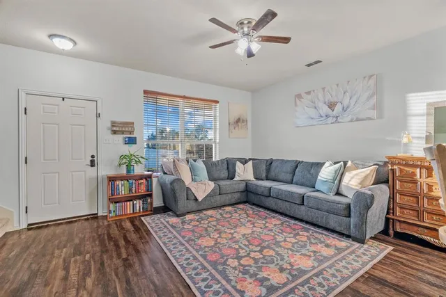 a living room with furniture and a wooden floor