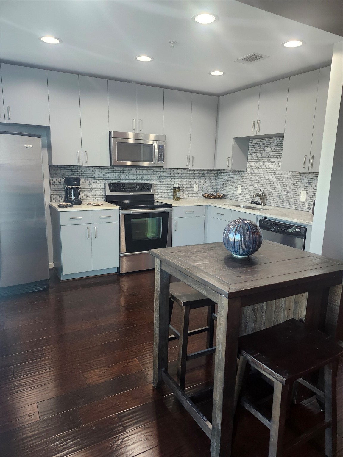 5925 Almeda Road, Unit 11513 Houston, TX 77004 - Photo 22 of 26 a kitchen with a sink a stove a refrigerator and white cabinets