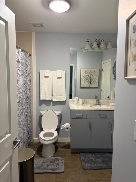 5925 Almeda Road, Unit 11513 Houston, TX 77004 - Photo 6 of 26 a bathroom with a granite countertop toilet a sink and a mirror